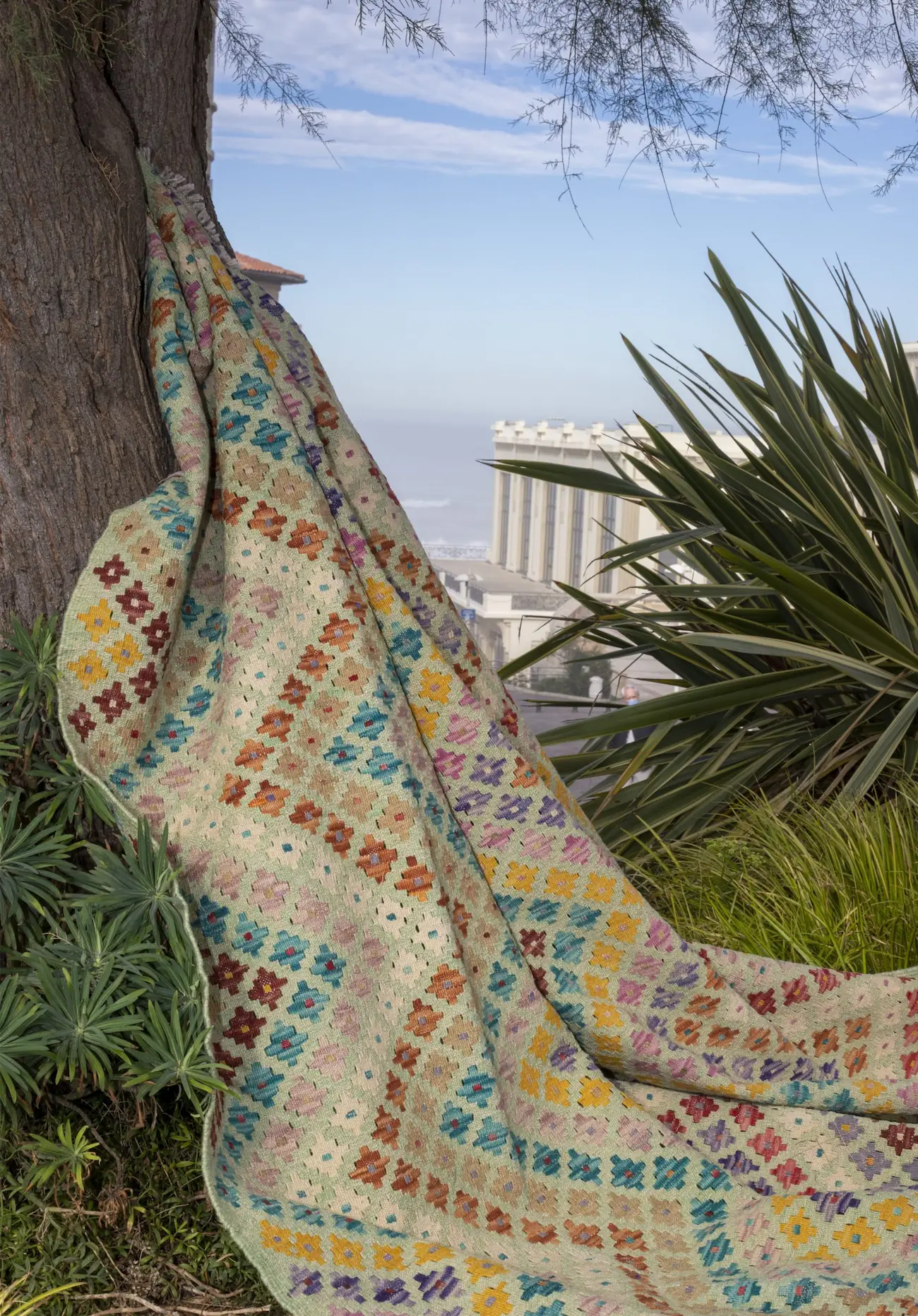 Kilim ethnique fait à la main aux teintes naturelles, mise en scène en bord de mer du Pays basque