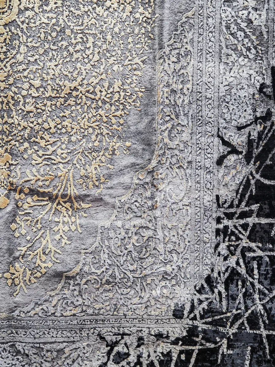 Détail tissage tapis de luxe motifs floraux or et argent Gros plan sur les motifs tissés dorés et argentés d'un tapis de luxe