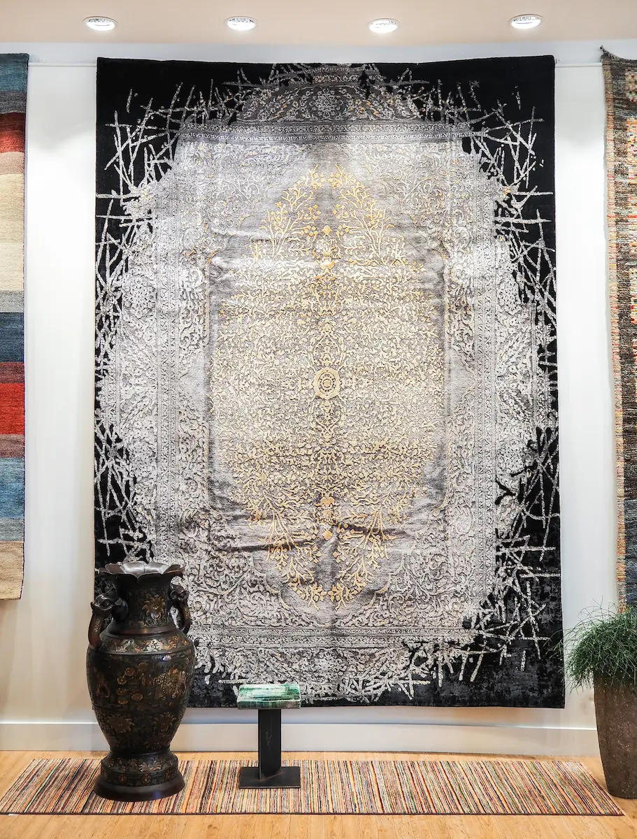 Tapis de luxe noir et argent à motifs orientaux raffinés Tapis noir et argenté à motifs orientaux suspendu en showroom